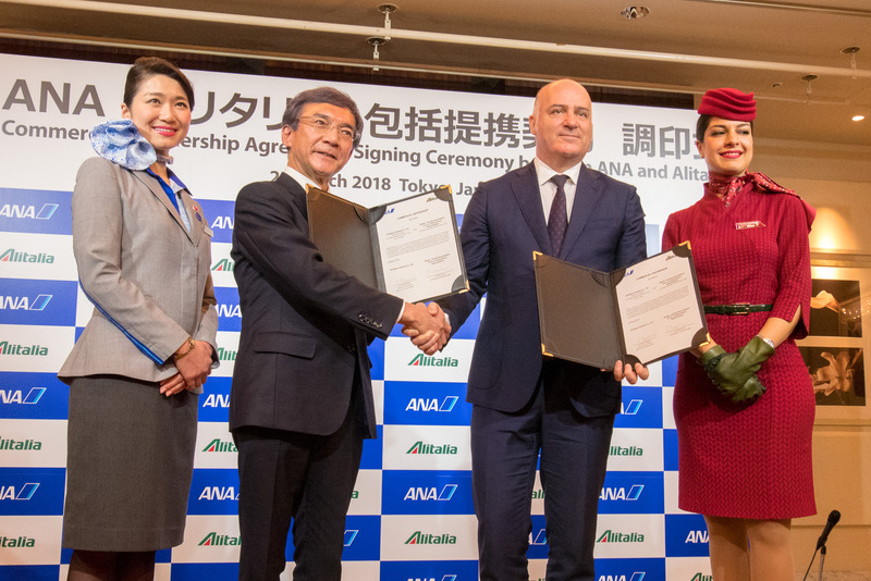 調印した書類を示し握手