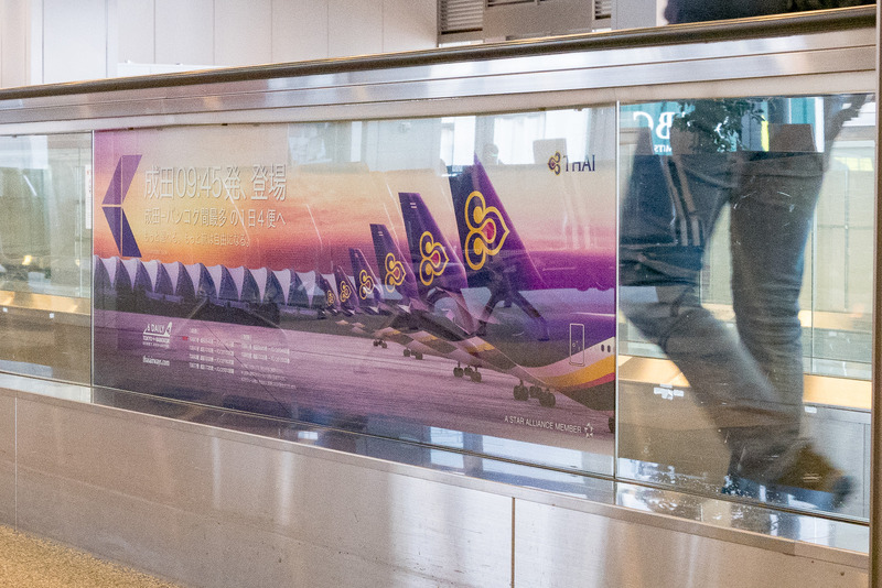 ムービングウォークに増便をアピールする広告も掲出