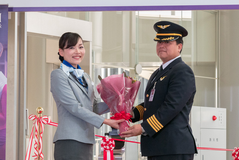 ANA成田エアポートサービス株式会社の土井郁子氏から、TG627便のパヤカパン・サンガポン機長へ花束を贈呈
