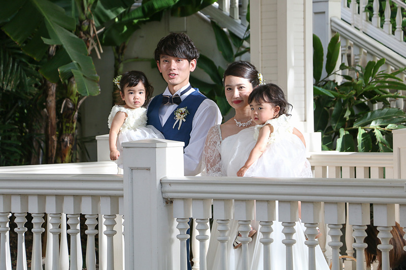 ゲストに祝福され、子供たちを抱いて大階段を歩く2人