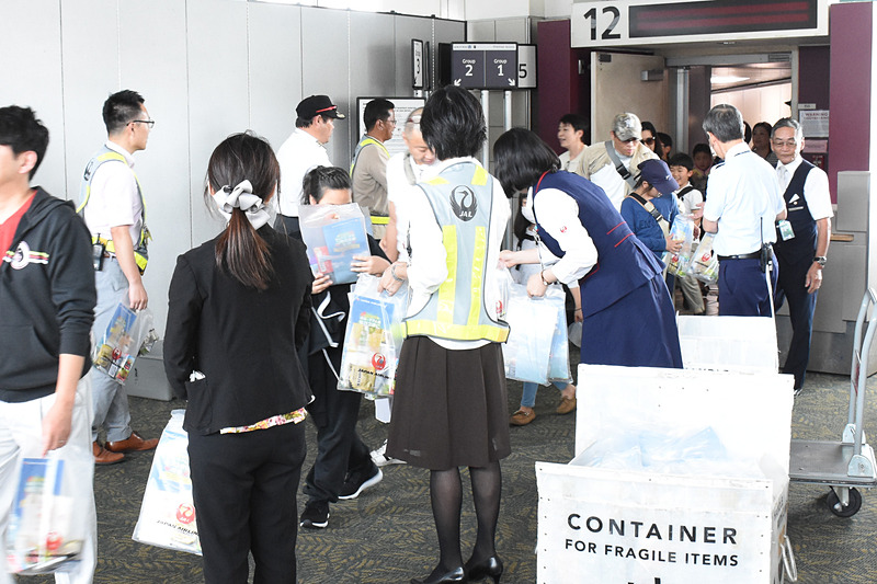 降機する利用者に記念品を手渡した