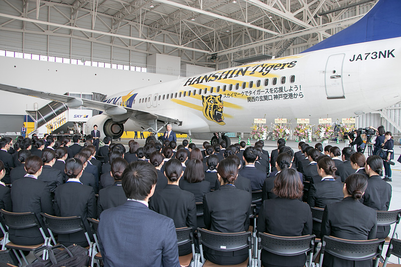 タイガースジェットの前で新入社員に語りかける佐山会長