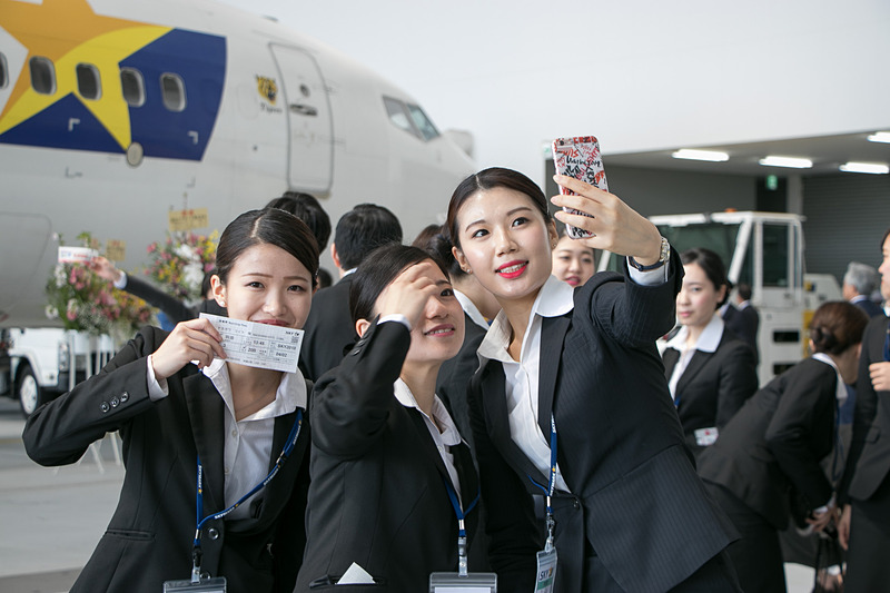 スマートフォンで記念撮影をする新入社員たち