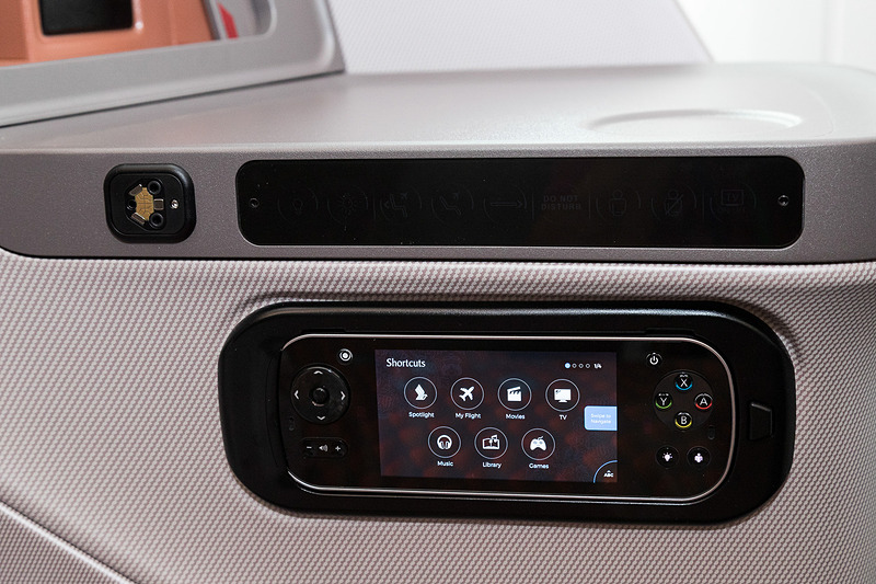 ミニテーブルの下にシートのリクライニング、機内エンタテイメントシステムのコントローラとヘッドフォンジャックが集約されている