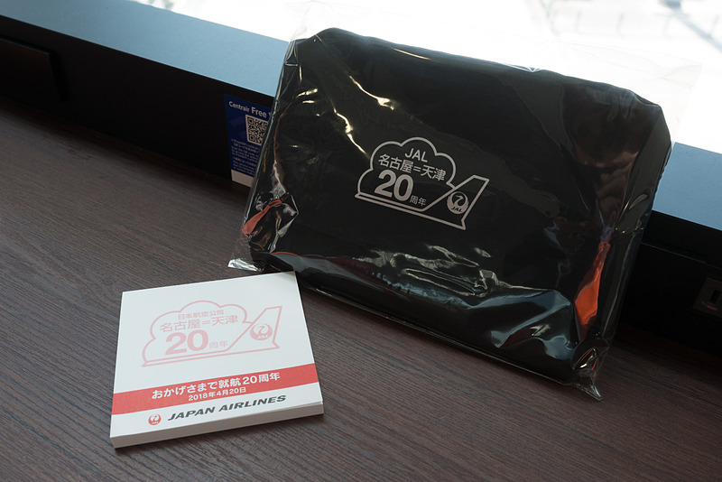 名古屋～天津線20周年の記念ロゴ入りエコバッグとメモ帳を搭乗客に配布