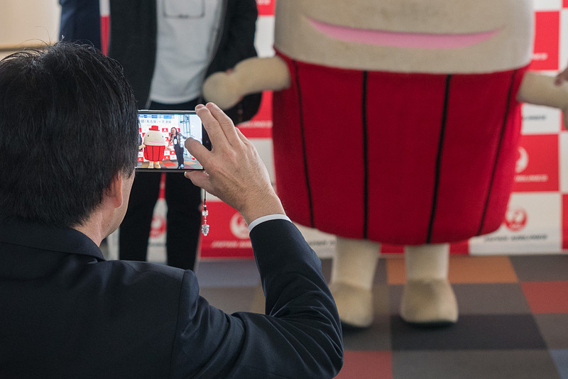 なぞの旅人フーやCAとの記念撮影で盛り上がる搭乗客