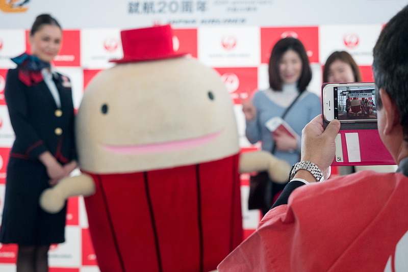 なぞの旅人フーやCAとの記念撮影で盛り上がる搭乗客