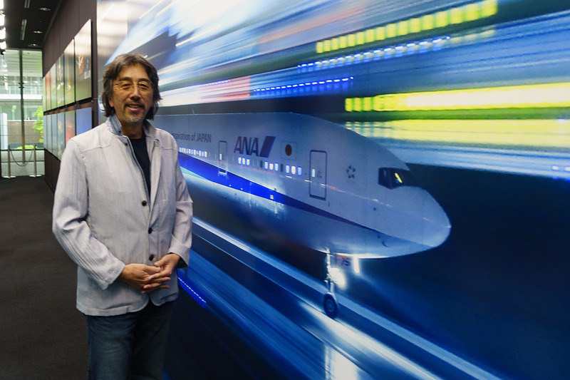 航空写真家のルーク・オザワ氏。写真展の入口付近で。飛行機がいまにも飛び立とうとしているように見えるため、記念撮影スポットにオススメとのこと