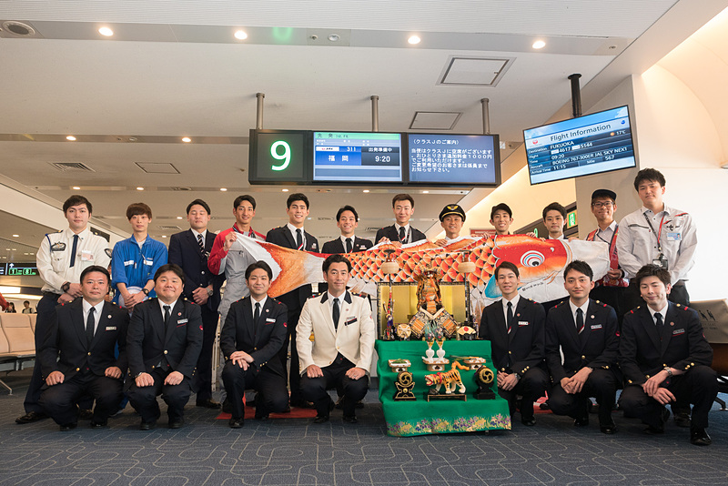 搭乗口まわりでのイベントに参加したさまざまな職種のスタッフ（後列）と、こいのぼりフライトの乗務員（前列）による記念撮影