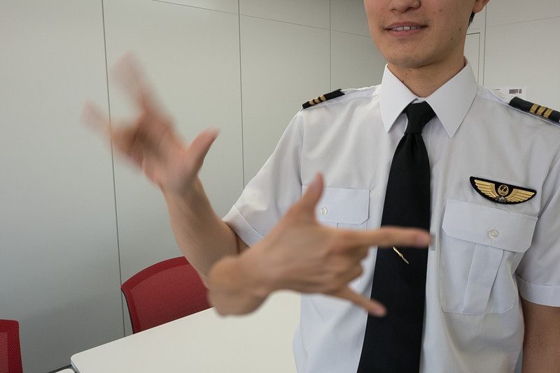 そのままJの形に手を動かせば「JAL」の意味に（2枚の画像を合成）