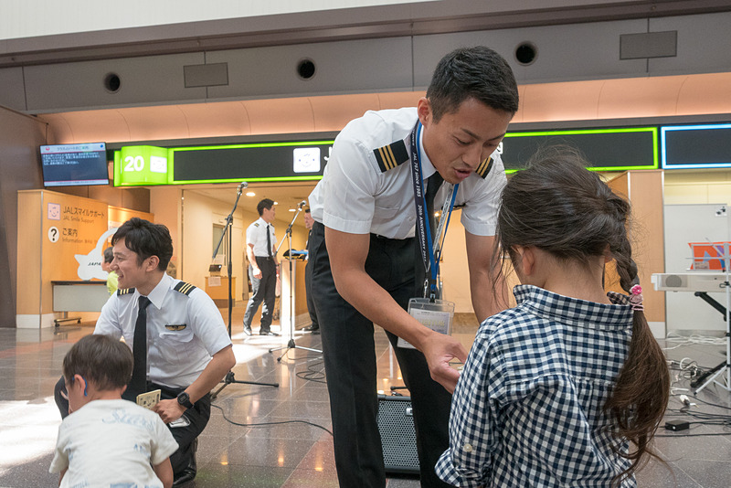 JALスマイルサポート前でのパフォーマンスでは子供を中心に多くの人が見学。パイロットから子供たちにシールが送られた。普段は乗客と接する機会が少ないパイロットにとっても貴重な機会になっている