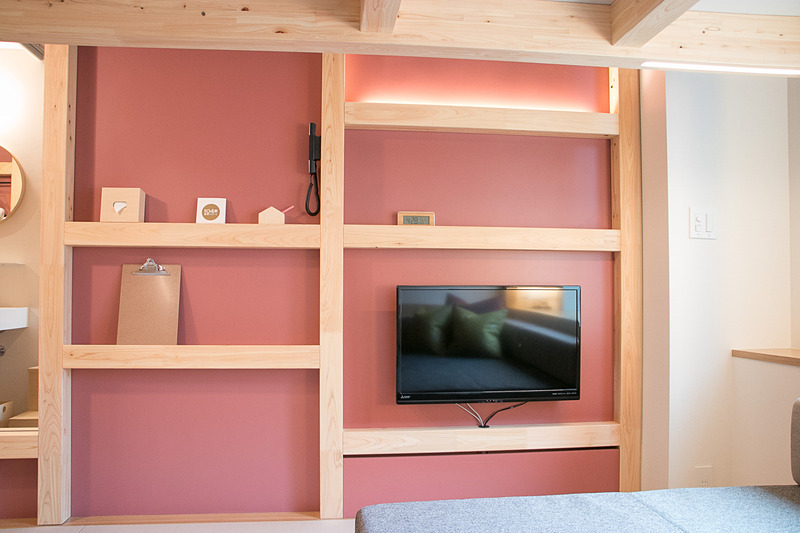 90cm角の角材を組み合わせた「仕掛け壁」によって壁面にも収納機能を持たせ、ハンガーやタオル、ドライヤーなどを収めている