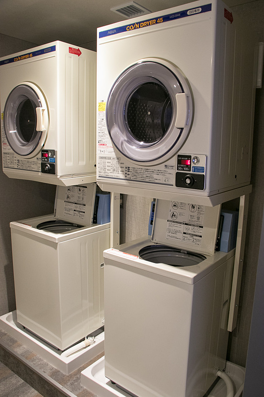 共用スペースに飲み物や追加のアメニティ類の自動販売機、洗濯機、アイロン・アイロン台などを用意している