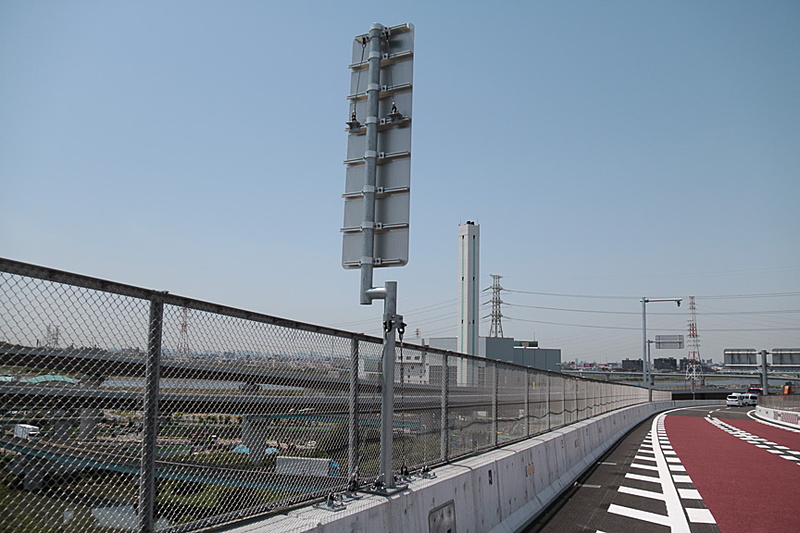 湾岸エリアのため強風時を考慮しワイヤーでつながれている標識と、昨今主流になりつつある高欄照明