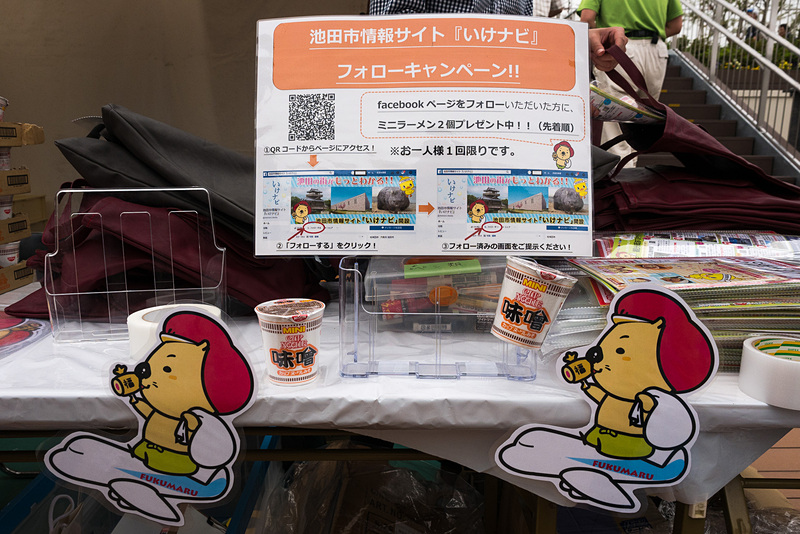池田市のブースは池田市情報サイト「いけナビ」の公式Facebookページのフォローキャンペーンでミニラーメン2個をプレゼント。写真右の袋に入れて、観光情報パンフレットなどと一緒にプレゼント