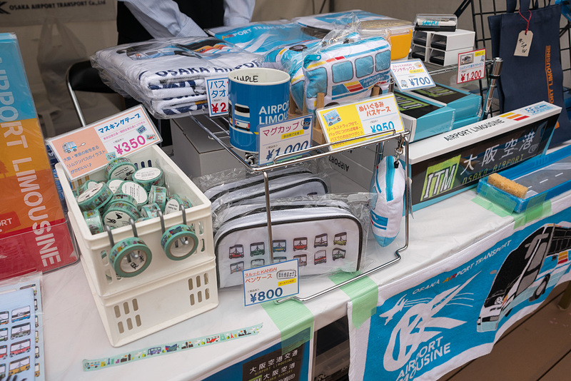 ブースは大阪空港交通グッズの販売。ミニカーなどが人気とのこと。創業55周年記念の方向幕タオルは本イベントで初の販売