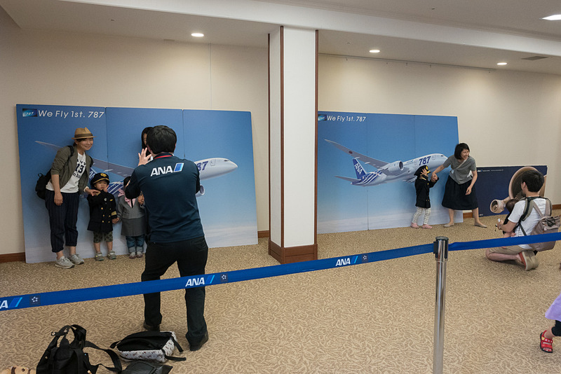 制服着用体験コーナー。ボーイング 787型機のバックパネルの前で記念撮影