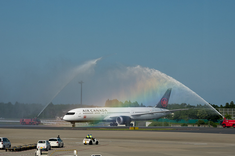 歓迎放水で迎えられるバンクーバー発初便のAC005便。虹がかかる美しいウォーターアーチをくぐって駐機場へ向かった