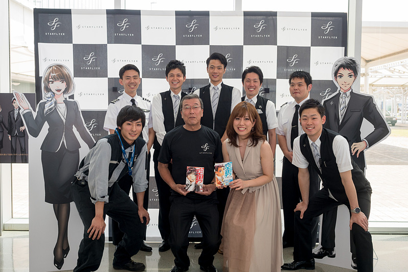 前方向かって中央右側が作者の糸川一成氏、同左側が株式会社スターフライヤー 代表取締役 社長執行役員 松石禎己氏。後方の5名は空男ソラダン MEN's FLIGHTのSFJ77便に乗務したパイロットとCA