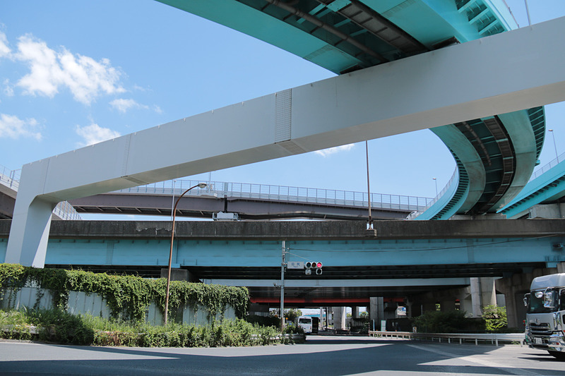 国道298号の終点となる田尻交差点から、高谷JCTを見上げた写真。橋梁の色でNEXCOのものと国土交通省のものとが分かれている