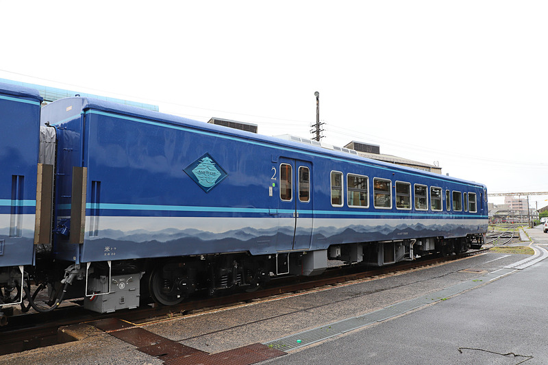 1号車（写真左）と2号車（写真右）の側面。帯模様は山並みにも日本刀の刃文にも見える