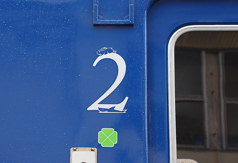 1号車と2号車ドア付近に書かれた号車表示。1号車は島根（出雲）、2号車は鳥取（因幡）を連想させるイラストをあしらっている