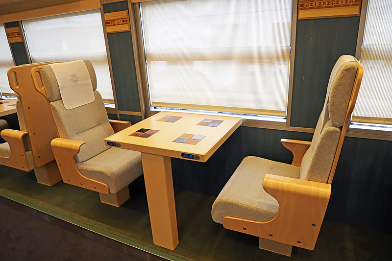 1号車（写真左）、2号車（写真右）ともに山側（奇数番号席）は2名掛けの対面シート。海が見えやすいように床面より一段高くなっている
