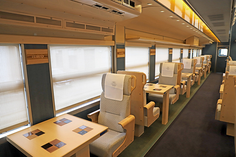1号車（写真左）と比較して2号車（写真右）の対面シートの一部は、さらに一段高くなっている。鳥取県をイメージした2号車のみの通称「大山シート」だ