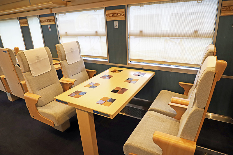 1号車（写真左）、2号車（写真右）の4名掛け対面シート。海側（偶数番号席）に各車両8席が用意されている