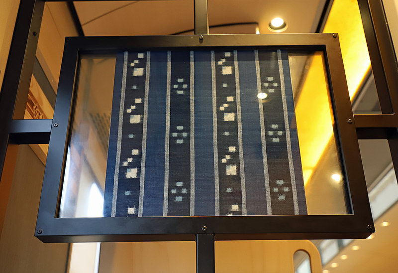 1号車ドア付近に展示された織物。写真左は出雲織、写真右は安来織で、いずれも島根県安来市で制作されたもの