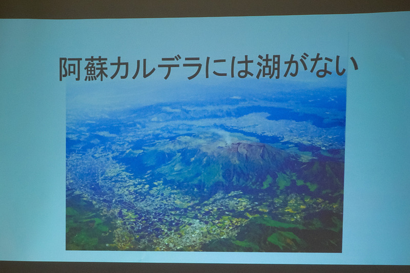 阿蘇ジオパーク協会 会長 児玉史郎氏による「すべての阿蘇は南阿蘇からはじまった」ことを紹介するプレゼン。写真中央の立体地図で指し示す場所が立野峡谷で、ここから水が流れ出したことで湖が消滅。1万年ほど前に南阿蘇に住んでいた人々は神様が蹴破った神話として語り継いでいる