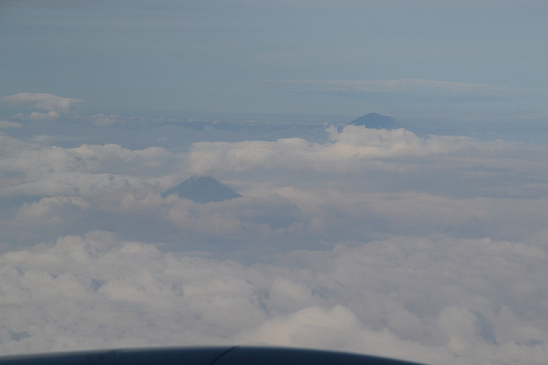 ふと窓の外を見ると雲の隙間から顔を出すバリ島の山々
