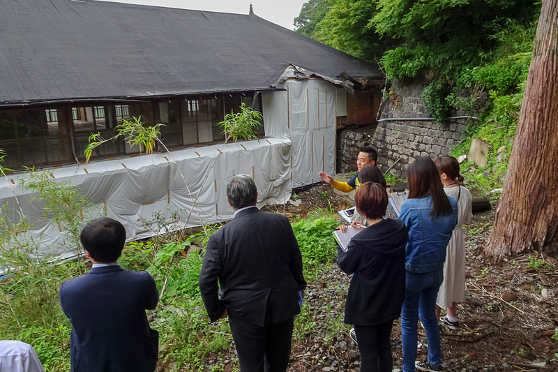 本館の裏手へ。土砂が流れ込んだ場所を避けるように、奥の方へと建築した設計が土砂災害を予想していたのではないかと話す