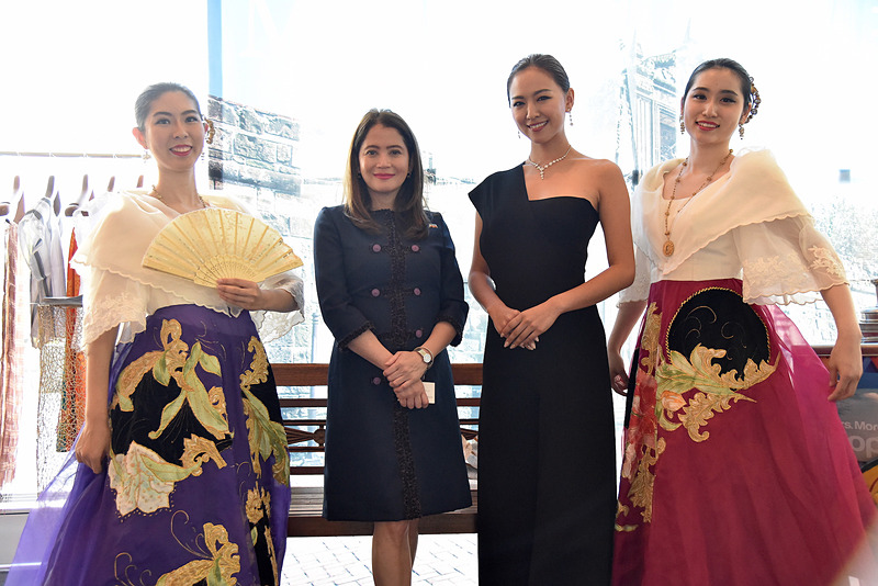 民族衣装姿のスタッフと大臣らが記念写真する姿も