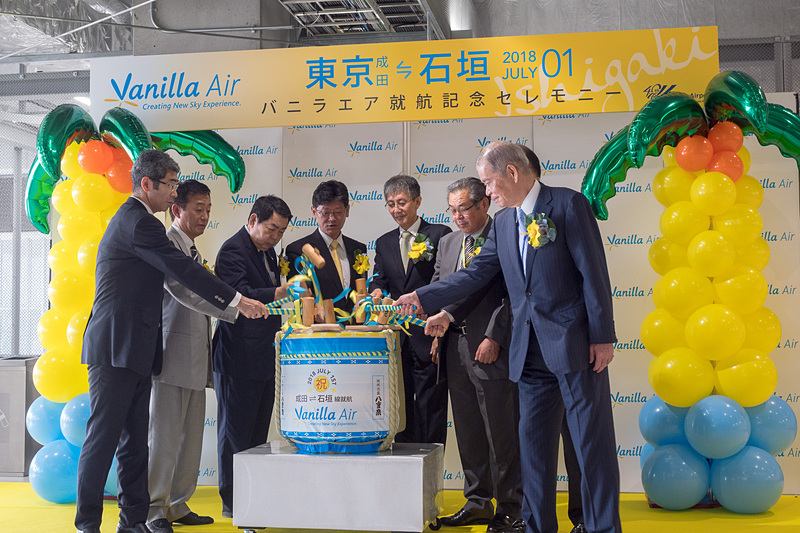 主催者と来賓が集まっての鏡開き。石垣島の蔵元が作る琉球泡盛「八重泉（やえせん）」の樽が用意された。参加者は左から順に、横芝光町 空港・地域振興室長 平山貴之氏、山武市 総務部長 石橋和記氏、成田市副市長 関根賢次氏、バニラ・エア株式会社 代表取締役社長 五島勝也氏、国土交通省 東京航空局 成田空港事務所 成田国際空港長 石井靖男氏、芝山町 町長 相川勝重氏、多古町長 所一重氏、成田国際空港株式会社 代表取締役社長 夏目誠氏