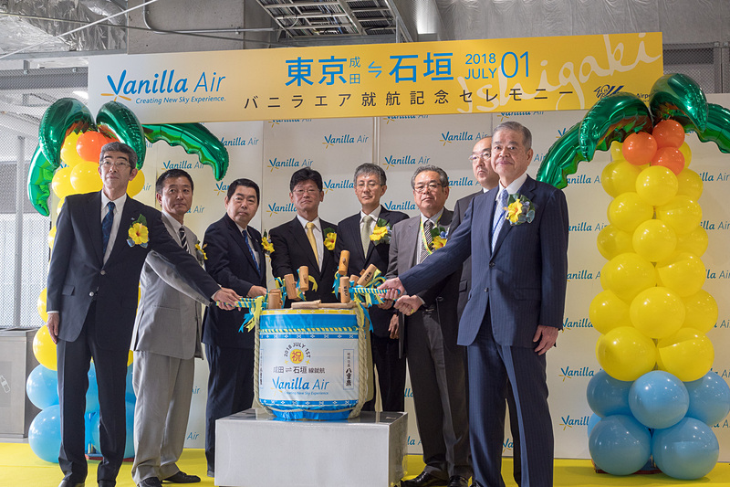 主催者と来賓が集まっての鏡開き。石垣島の蔵元が作る琉球泡盛「八重泉（やえせん）」の樽が用意された。参加者は左から順に、横芝光町 空港・地域振興室長 平山貴之氏、山武市 総務部長 石橋和記氏、成田市副市長 関根賢次氏、バニラ・エア株式会社 代表取締役社長 五島勝也氏、国土交通省 東京航空局 成田空港事務所 成田国際空港長 石井靖男氏、芝山町 町長 相川勝重氏、多古町長 所一重氏、成田国際空港株式会社 代表取締役社長 夏目誠氏