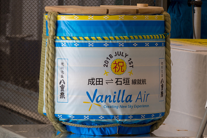 主催者と来賓が集まっての鏡開き。石垣島の蔵元が作る琉球泡盛「八重泉（やえせん）」の樽が用意された。参加者は左から順に、横芝光町 空港・地域振興室長 平山貴之氏、山武市 総務部長 石橋和記氏、成田市副市長 関根賢次氏、バニラ・エア株式会社 代表取締役社長 五島勝也氏、国土交通省 東京航空局 成田空港事務所 成田国際空港長 石井靖男氏、芝山町 町長 相川勝重氏、多古町長 所一重氏、成田国際空港株式会社 代表取締役社長 夏目誠氏