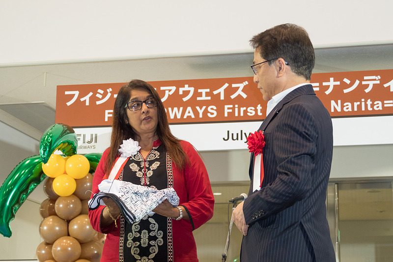 フィジー・エアウェイズのシェナーズ・ヴォス氏からNAAの荒川武氏へ、フィジー・エアウェイズのロゴと「350」便を背番号にデザインしたTシャツをプレゼント