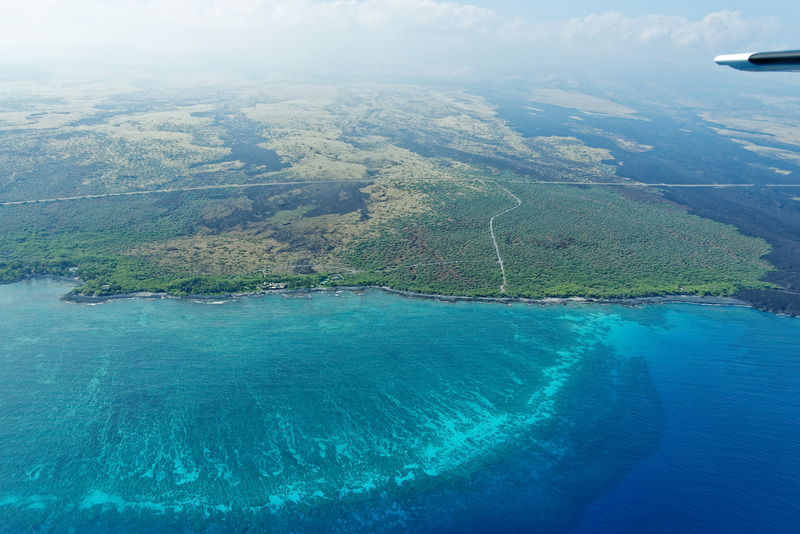 エメラルドブルーの海と地表の無機質な黒との対比が美しい