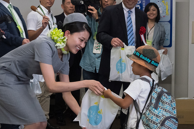 関係者が搭乗客に記念品をプレゼント