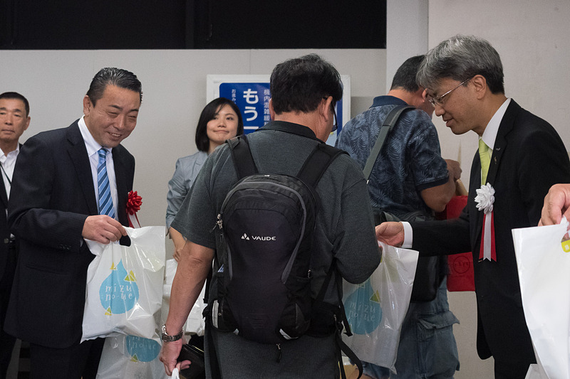 関係者が搭乗客に記念品をプレゼント