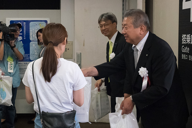 関係者が搭乗客に記念品をプレゼント