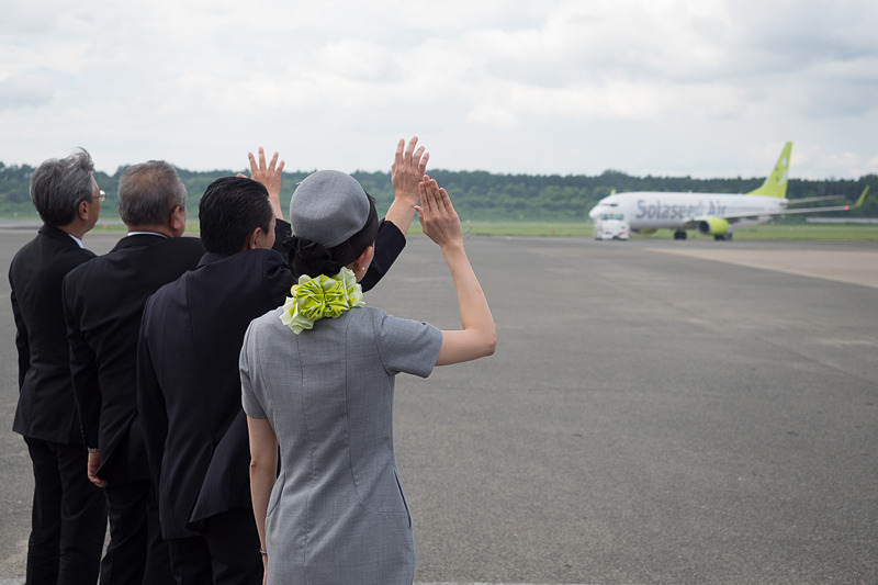 水上村長 中嶽弘継氏、水上村商工会 会長 山崎隆浩氏、株式会社ソラシドエア 代表取締役社長 髙橋宏輔氏、同社CAが駐機場から手を振ってお見送り
