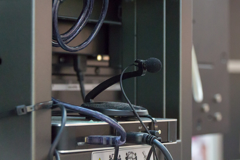 デジタルサイネージの背面には、音声信号を検出するためのマイクと案内画面を表示するためのコントローラが取り付けられている。こちらのデジタルサイネージはミライスピーカーより30m離れた場所に設置されていたが、音声アナウンスが流れると瞬時に表示情報が更新されていた