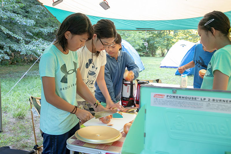お風呂から戻ると夕飯作り。この日のメニューはキャンプの定番であるカレー。ご飯は大人が担当。カレー作りは子供たち全員が手分けして行なった