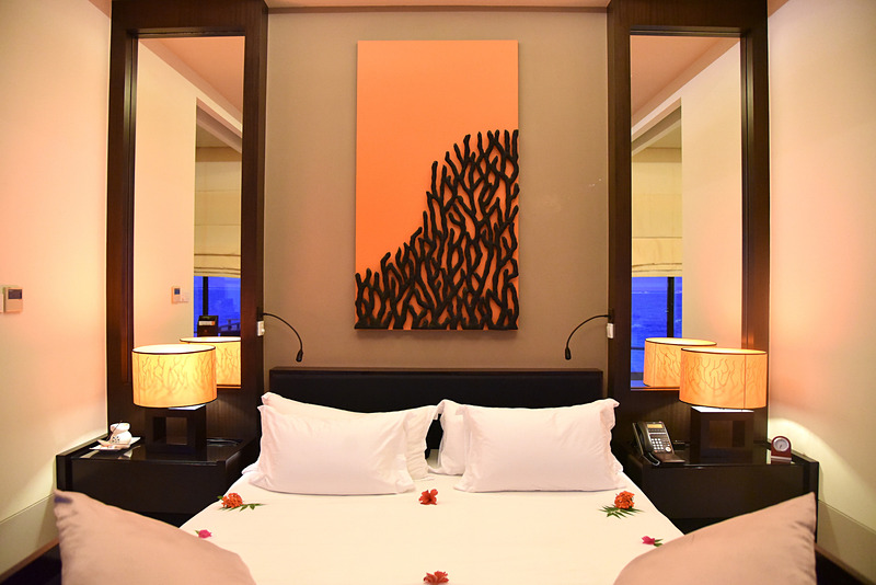 部屋の中央にキングサイズのベッドが鎮座。ターンダウン前は花々でデコレーション