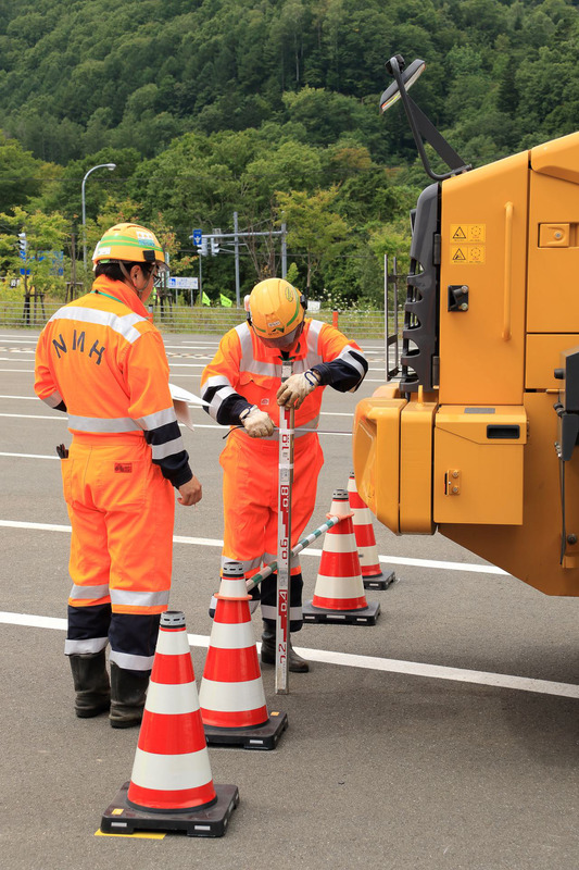 車庫入れが終了するとポールと車両の間隔を計測し、次の選手に交代する。
