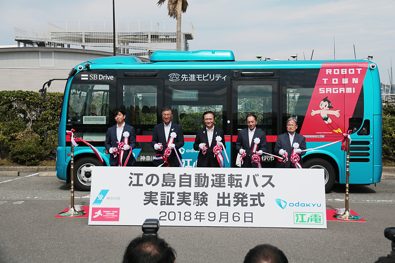 出発式のテープカットを行なった。左からSBドライブ株式会社 代表取締役社長兼CEO 佐治友基氏、藤沢市長 鈴木恒夫氏、神奈川県知事 黒岩祐治氏、小田急電鉄株式会社 取締役社長 星野晃司氏、江ノ島電鉄株式会社 取締役社長 楢井進氏の5名