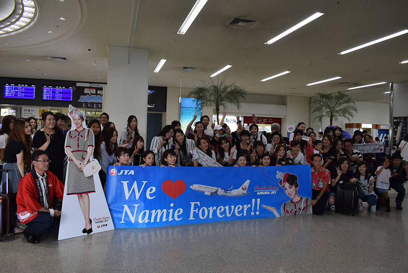 横断幕を囲むように大勢が集まっての記念撮影