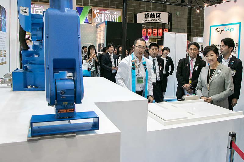 小池都知事がスタートボタンを押すとロボットアームが動き、「Tokyo Tokyo」のスタンプを押印した